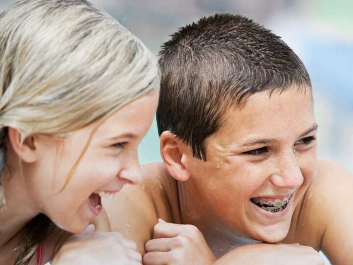 traditional metal braces worn by Melbourne smiling kids in pool orthodontics Essendon clinic